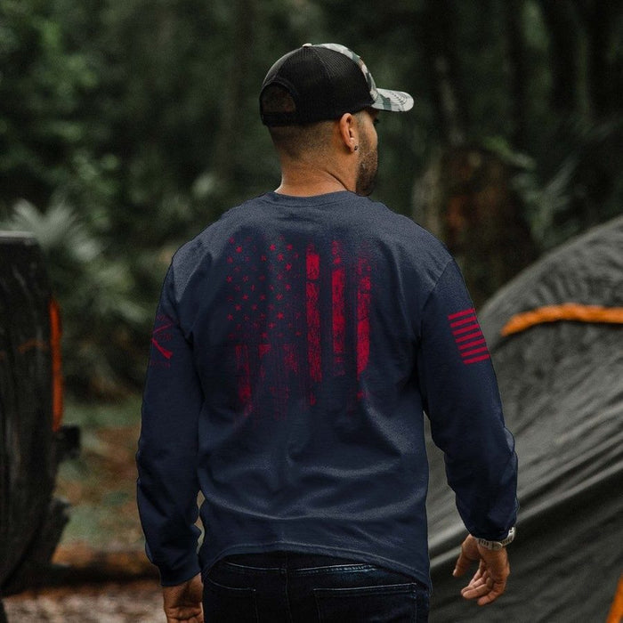 Man wearing a navy blue sweatshirt with red graphics, standing outdoors with blurred background