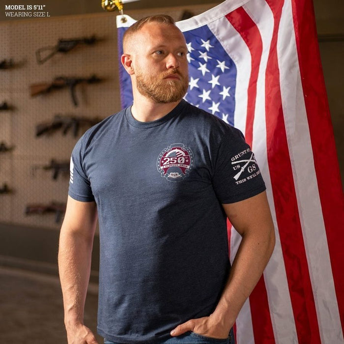 Man wearing a navy t-shirt with a logo in front of an American flag