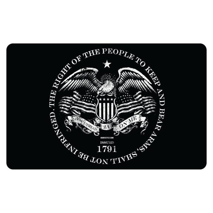 A black rectangular mat or plaque with rounded corners, featuring a large white circular emblem of an eagle, shield, and crossed rifles, surrounded by the text 'THE RIGHT OF THE PEOPLE TO KEEP AND BEAR ARMS SHALL NOT BE INFRINGED' and 'ISSUED 1791'.