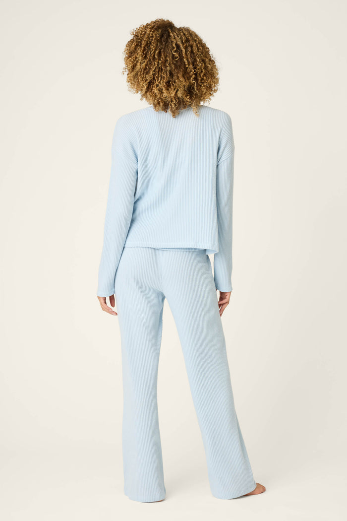 A woman wearing the P.J. Salvage 3-Piece Luxe Ribbed Celestial PJ Set in light blue.