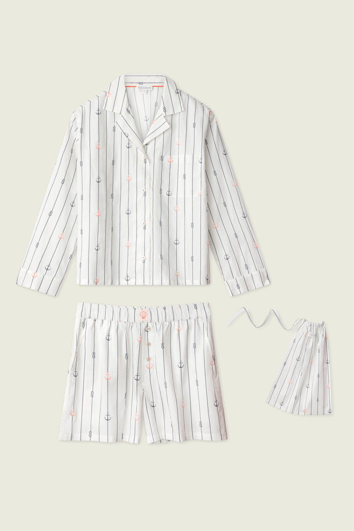 The Afterparty Poplin Anchors Away Short PJ Set by P.J. Salvage features cotton poplin pajamas with a long-sleeve button-up shirt, drawstring shorts, and a matching pouch in ivory with black stripes and pink/blue anchor patterns.