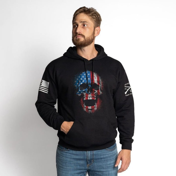 Man wearing a black hoodie with a skull design and American flag on a white background