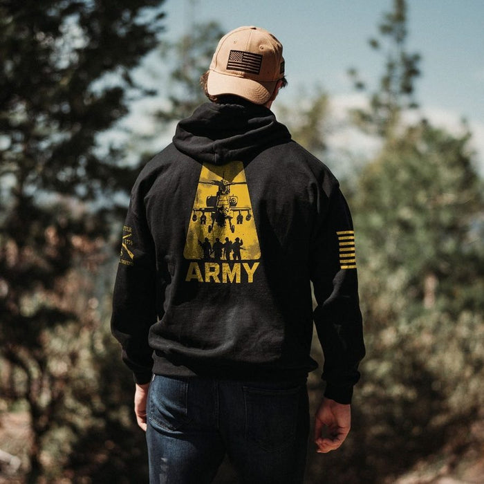 Person wearing a black hoodie with 'ARMY' and a graphic on the back, standing outdoors.
