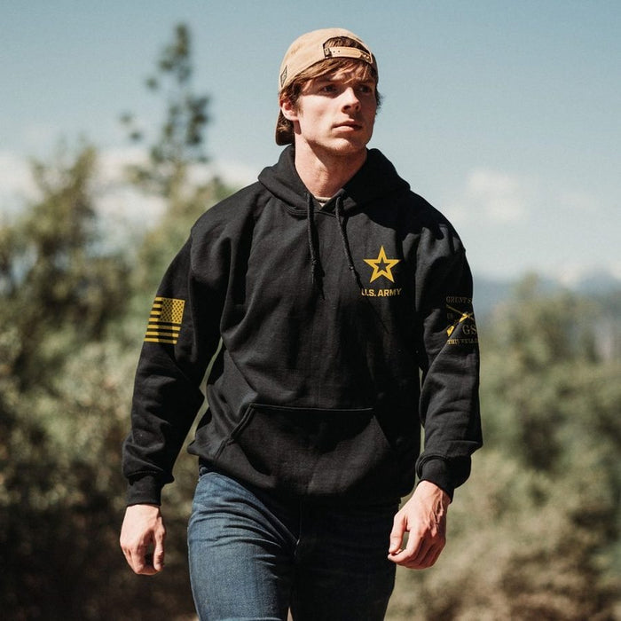 Person wearing a black hoodie with a star emblem and text, standing outdoors.
