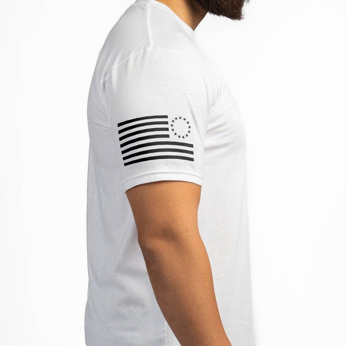 White t-shirt with black flag design on sleeve against a white background