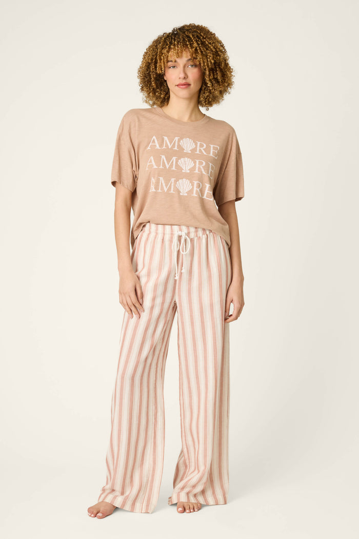 A loose tan fabric with AMORE and shell graphics paired with wide-leg pink and white striped material and a drawstring waist.