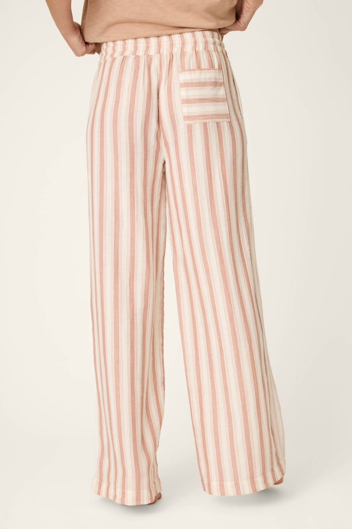 Pink and white vertical stripes with a pocket featuring horizontal stripes; fabric appears loose, soft, and lightweight.