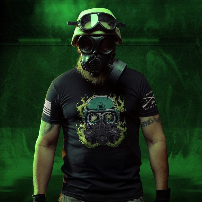 Person wearing a gas mask and black t-shirt with a graphic design on a green background