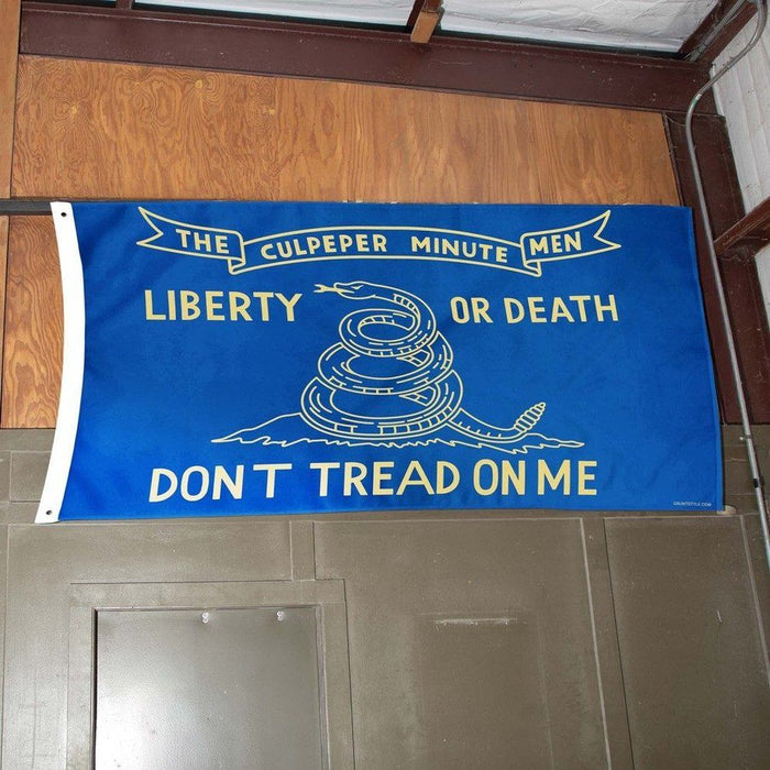 Blue flag with white text and snake design on a wooden door