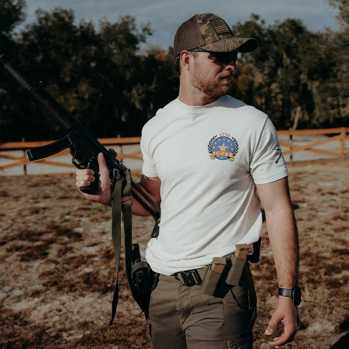 Man holding a rifle outdoors with a forest background