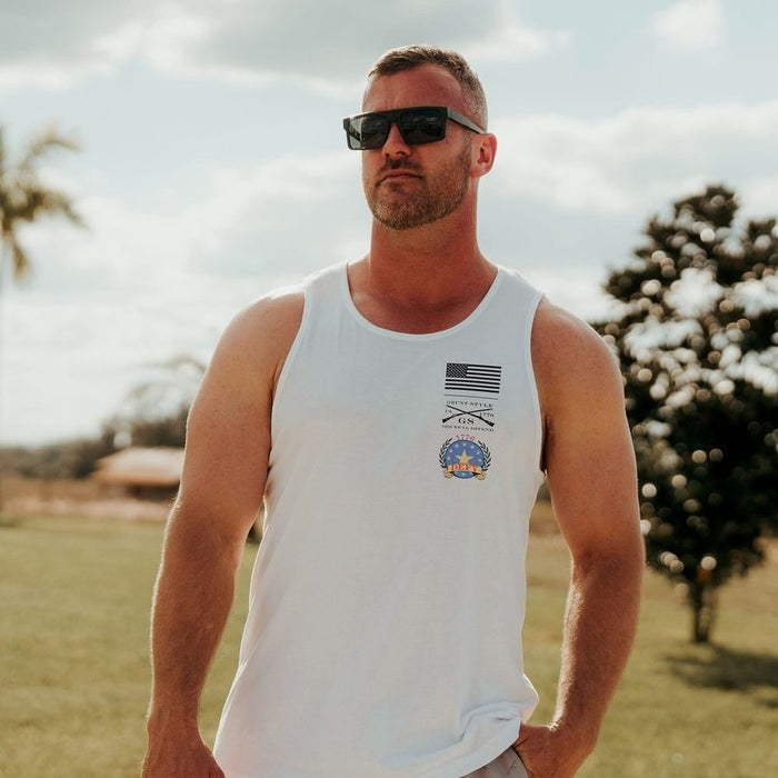 Man wearing a white tank top with a logo outdoors