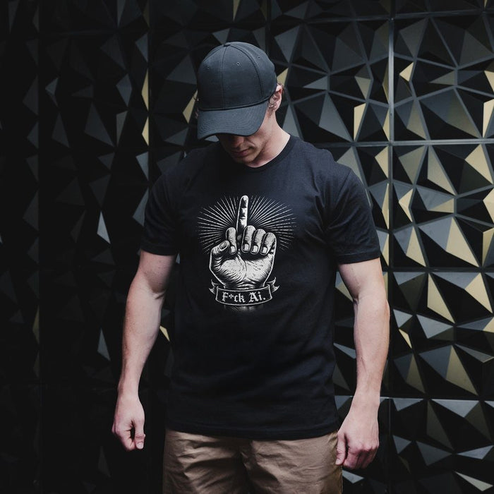 Person wearing a black t-shirt with a graphic design against a geometric patterned wall.