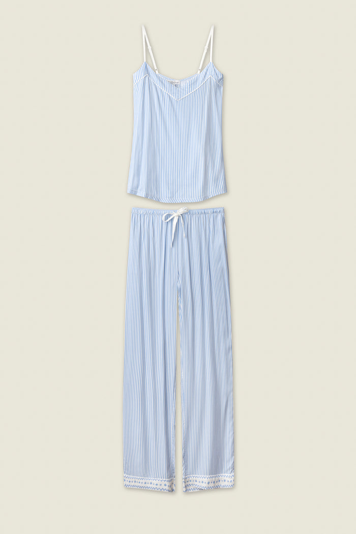 The P.J. Salvage Frutta Fresca Striped Long Lounge Set features thin blue and white stripes, a sleeveless spaghetti strap top, and matching drawstring pants with lace-trimmed hems, shown laid flat on a light beige background.