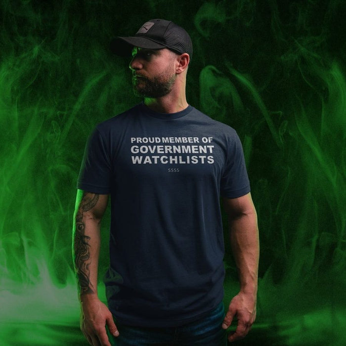 Man wearing a navy blue t-shirt with text standing against a green smoke background