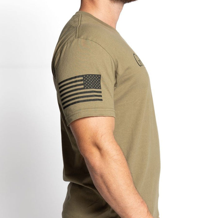 Person wearing a green t-shirt with an American flag patch on a white background