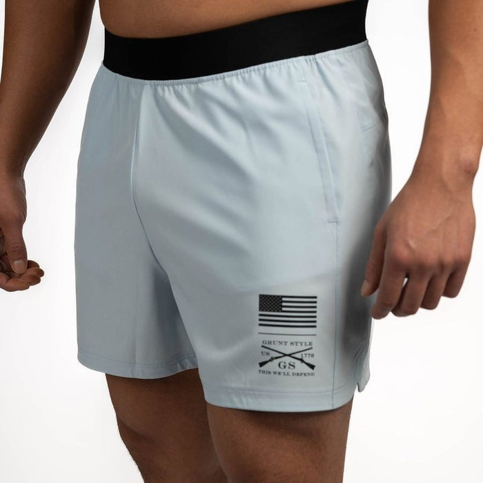 Light gray shorts with a black and white logo on a plain background
