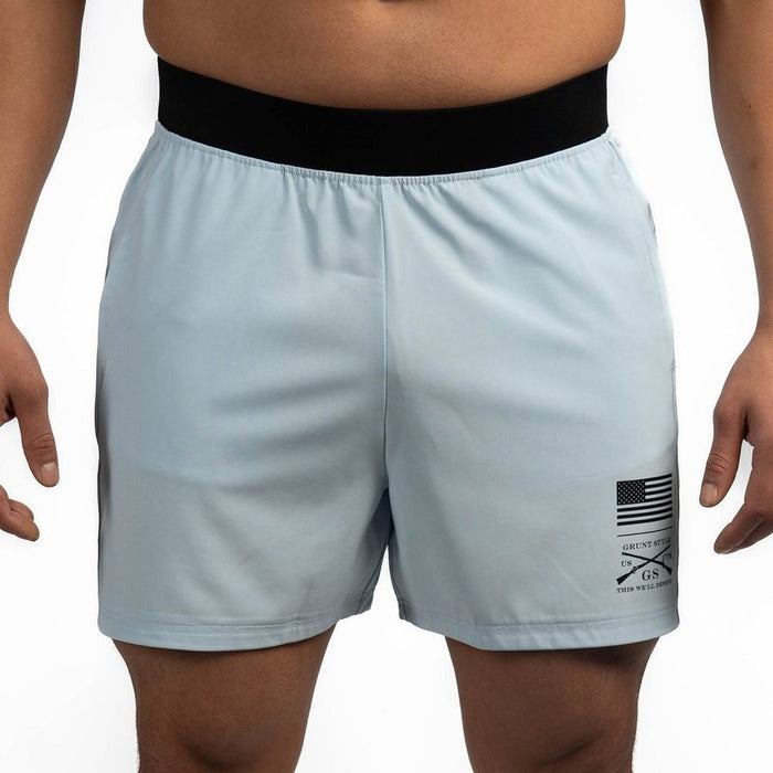 Light blue athletic shorts with a black waistband and small flag logo on a white background