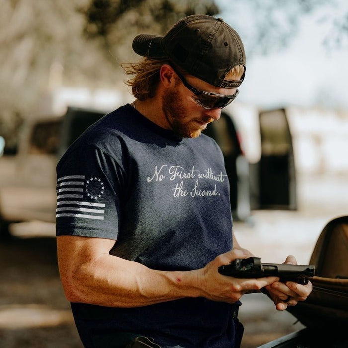 Man holding a handgun outdoors with a blurred background