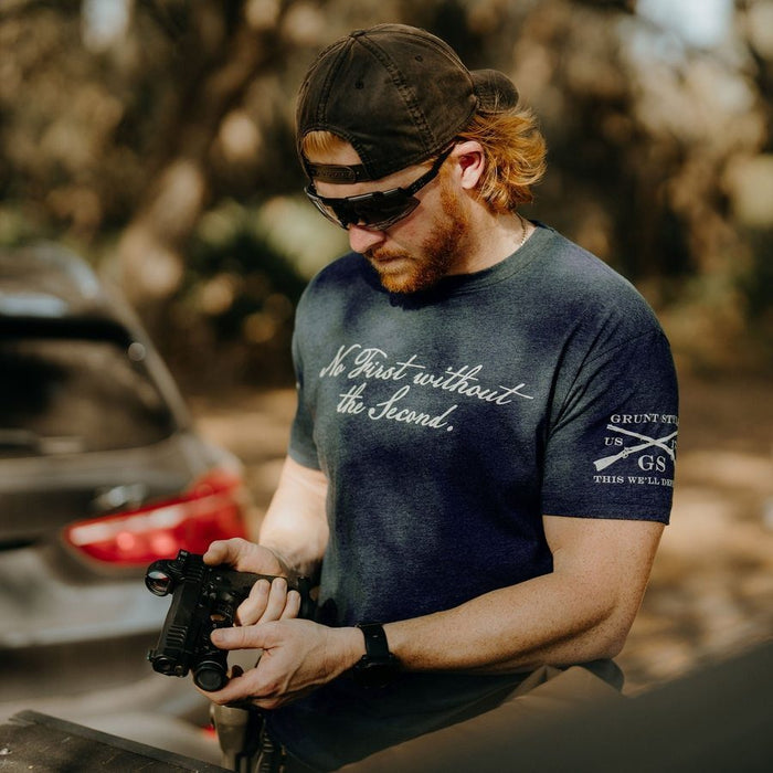 Man holding a rifle outdoors with a blurred background