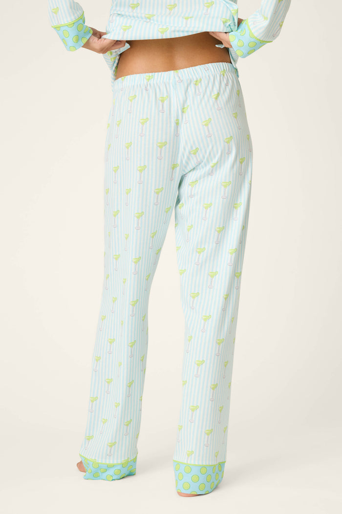 Shown from the back, a person wears P.J. Salvage’s Playful Prints Island Time Short PJ Set—light blue and white vertical stripes with light green accents and wide polka dot cuffs in cotton-modal jersey, plus a matching slightly cropped top.