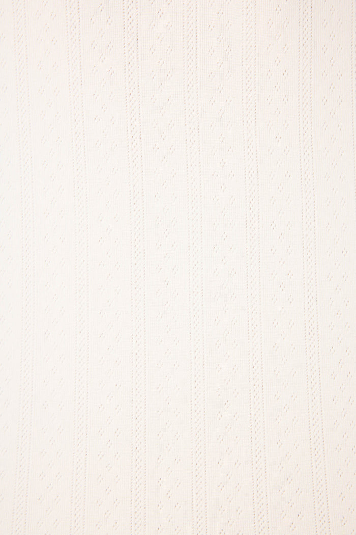 A close-up of the Pointelle Essentials Ivory Cardigan by P.J. Salvage shows its uniform, subtly raised vertical stripes and dotted texture in light beige fabric.