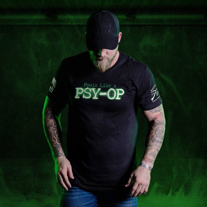 Man wearing a black t-shirt with text and a cap on a green background