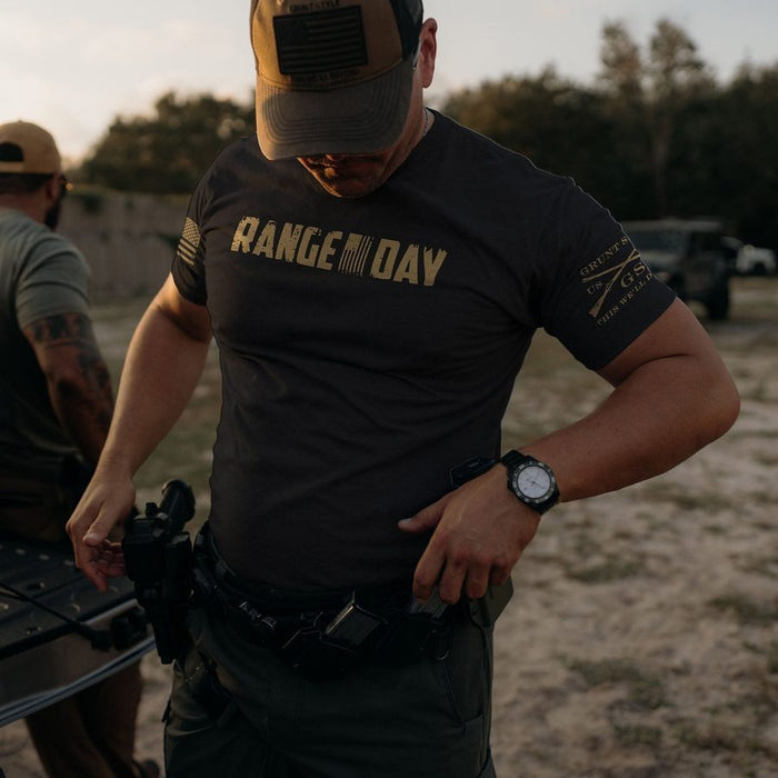 Man wearing a 'RANGE DAY' t-shirt outdoors with another person in the background.