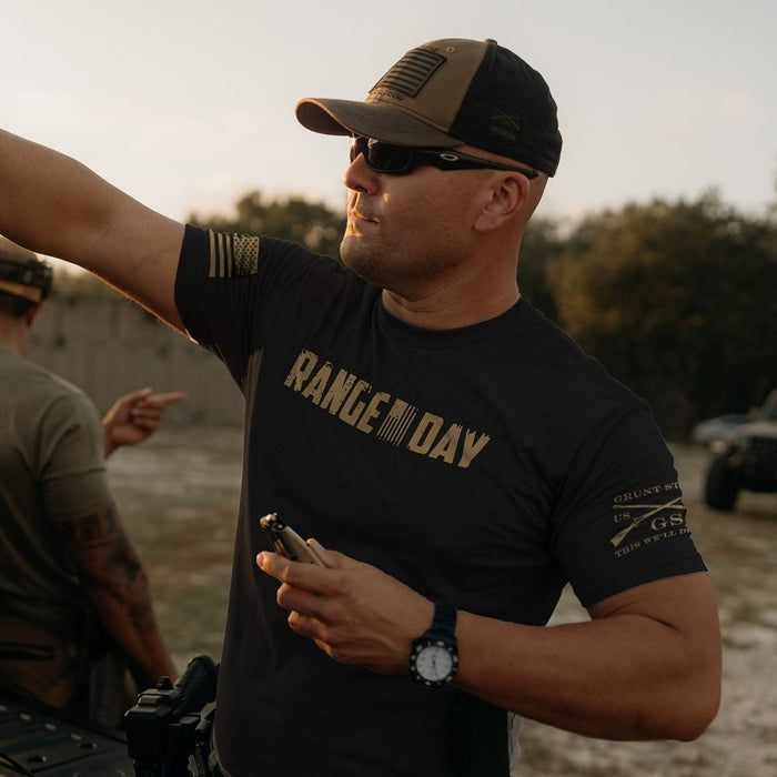 Man wearing a 'RANGE DAY' t-shirt outdoors with sunset or sunrise in the background