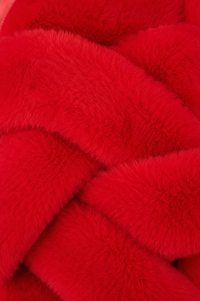 Close-up of vibrant red, fluffy faux fur from the P.J. Salvage Red Faux Fur Slippers, arranged in overlapping, crisscrossed sections that highlight the soft, plush texture—reminiscent of their cozy design with comfortable rubber soles.