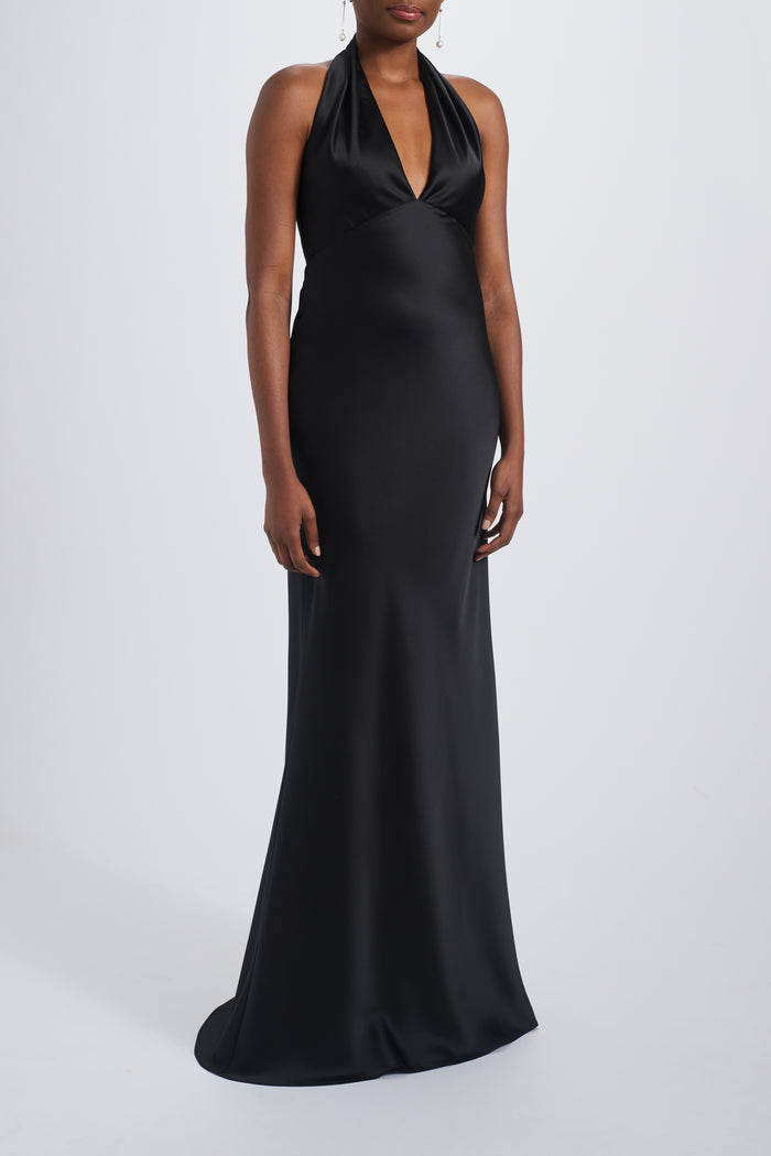 A woman wearing a black sleeveless maxi dress with a v-neck neckline.