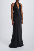 A woman wearing a black sleeveless maxi dress with a v-neck neckline.