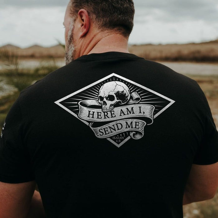 Man wearing a black t-shirt with a skull design and text outdoors