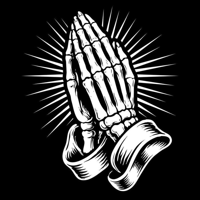 Skeletal hands in a prayer position with rays of light on a black background