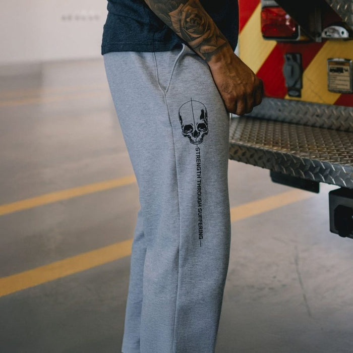 Person wearing gray sweatpants with a skull design in a garage setting