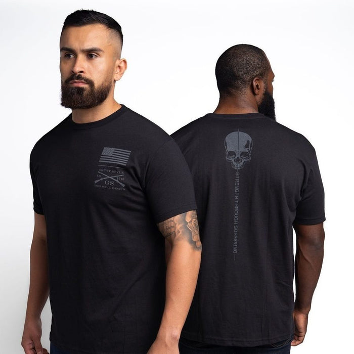 Two men wearing black t-shirts with designs on the front and back, standing side by side.