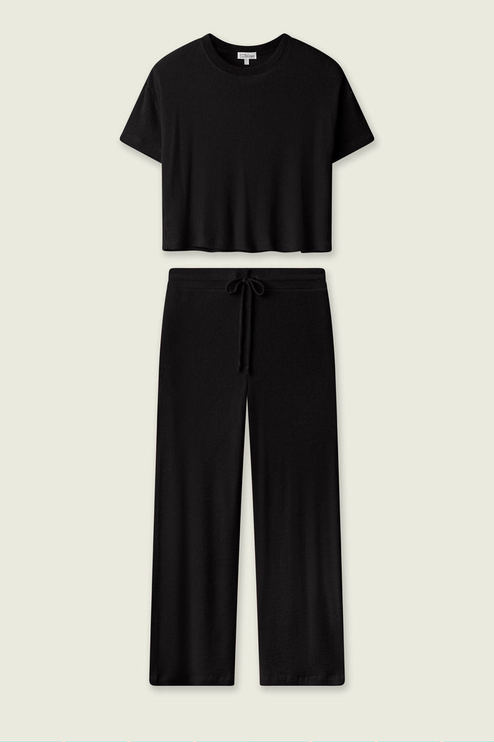 The P.J. Salvage Textured Essentials Black Long PJ Set features a short-sleeve cropped crewneck top and wide-leg drawstring pants, shown on a plain light background—ideal cozy loungewear for stylish relaxation.
