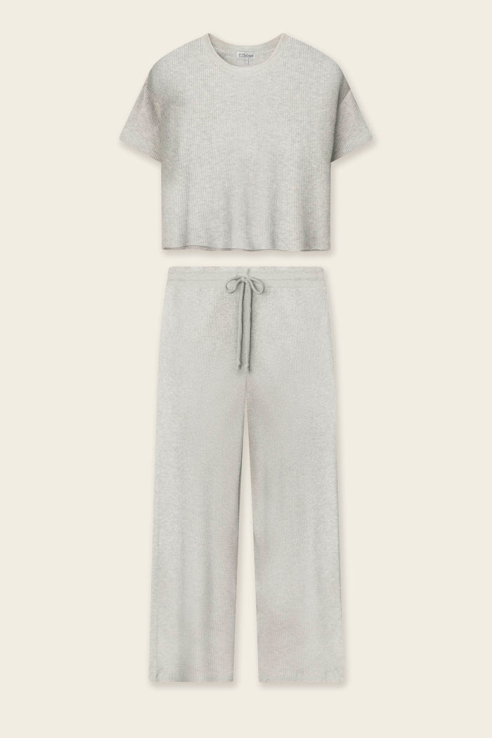 The P.J. Salvage Textured Essentials Heather Grey Long PJ Set features a soft rib knit lounge set with a cropped crew-neck short-sleeve top and wide-leg drawstring pants, shown flat on a beige background.