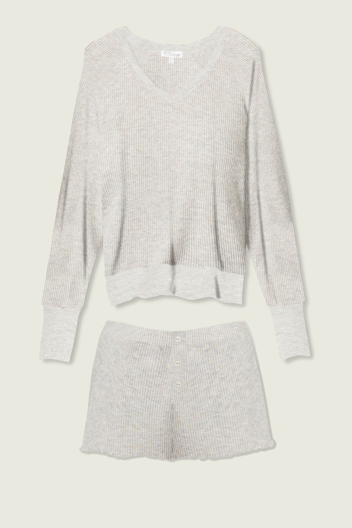 The P.J. Salvage Textured Essentials Heather Grey Short Lounge Set features a light gray ribbed knit, with a long-sleeve V-neck top and button-detailed shorts, shown laid flat on a light background.