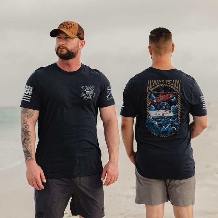 Man wearing a black t-shirt with a design on the front and back, standing on a beach.