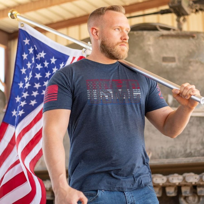 Man holding a baseball bat with an American flag in the background